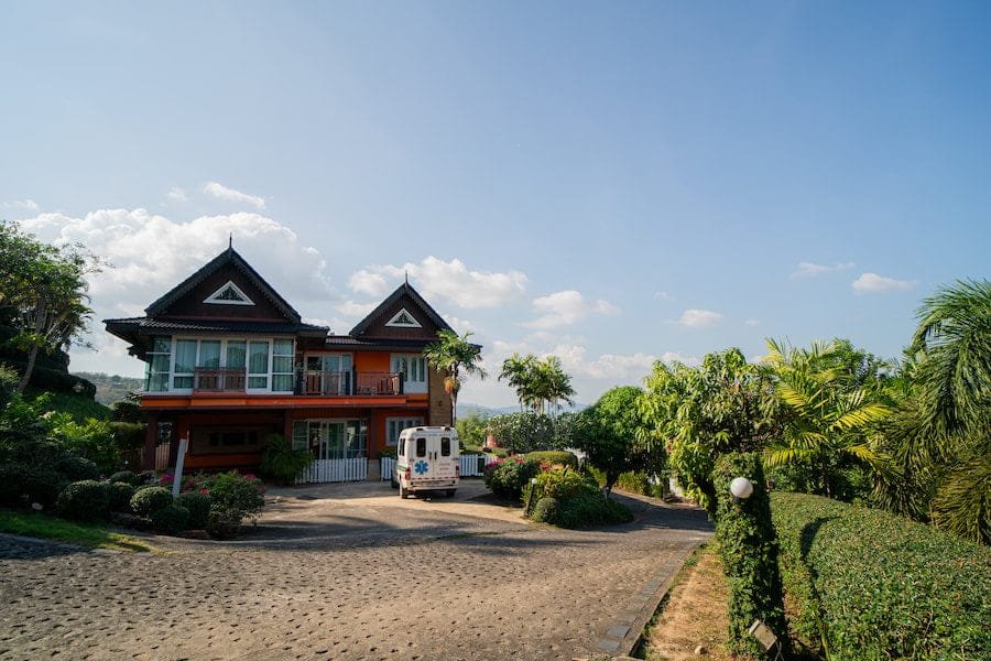 A house with a driveway and a parked vehicle, illustrating the serene atmosphere of best rehab Thailand facilities. phuket island rehab
